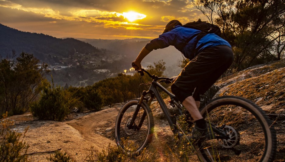 Mountain biking al tramonto su terreno accidentato